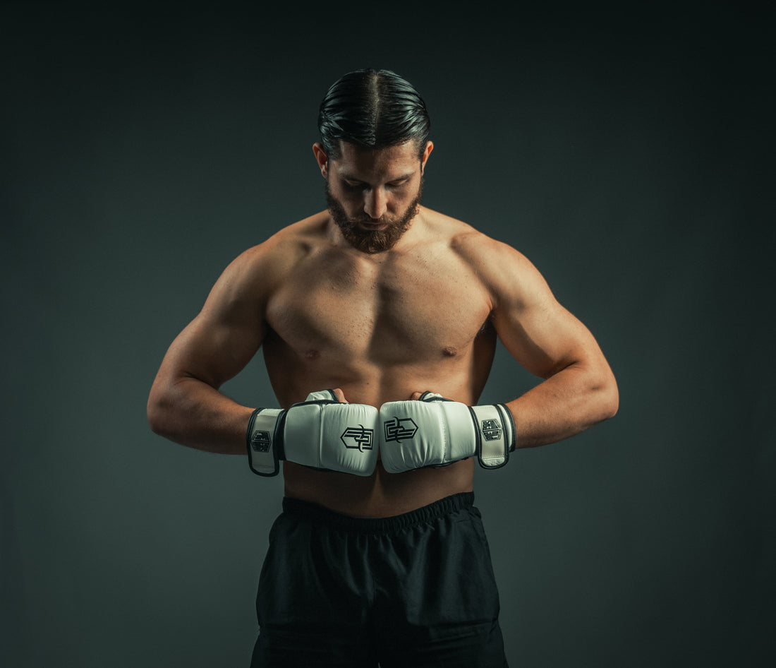 Vechtsporter met witte MMA-handschoenen tegen een donkere achtergrond